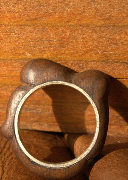 Wooden ring with a metallic band on a wooden surface